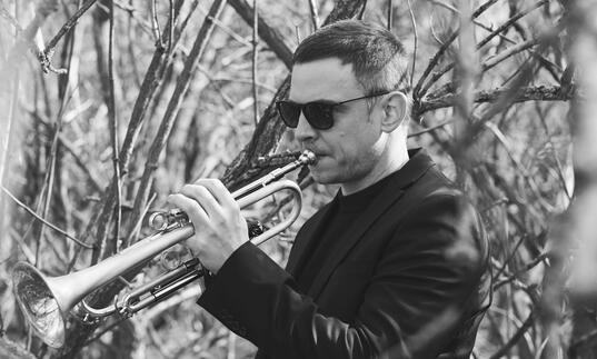 Image of Lőrinc Barabás playing the trumpet in black and white 
