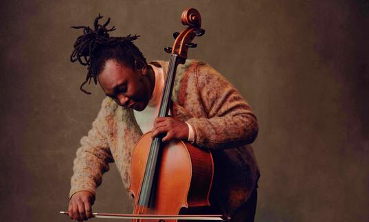 Abel standing and playing the cello