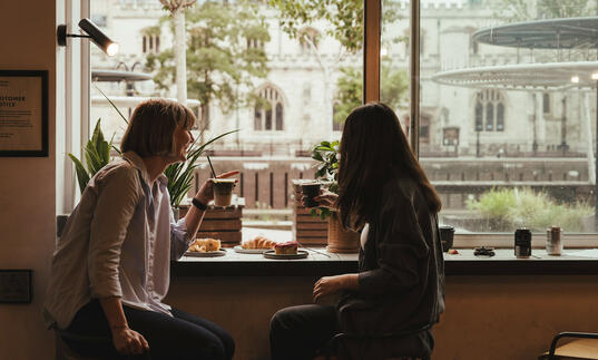 Two women enjoy coffee at Barbican Kitchen