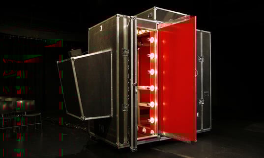 The theatre for one pop-up booth, a photo of a black and red container with show lights.