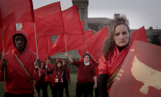 A group wearing red clothes and waving red flags