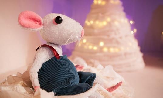 A photo of a mouse puppet against a snowy background